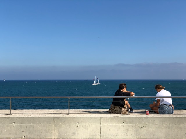 Two people sitting near the ocean discussing depression and mental health