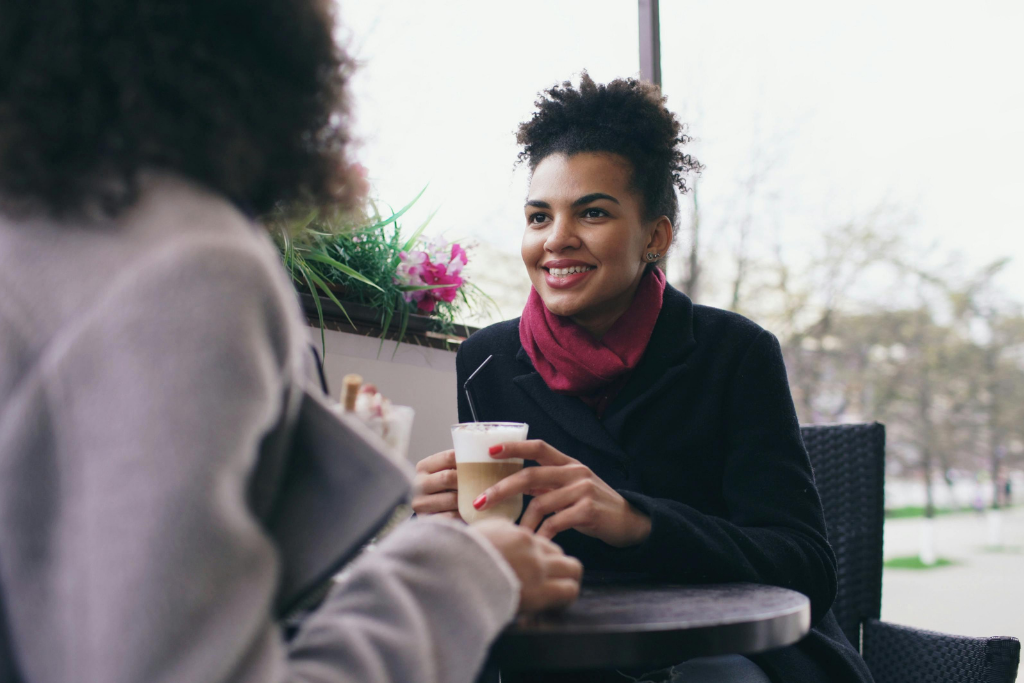 Woman smiling with colleague therapist over coffee