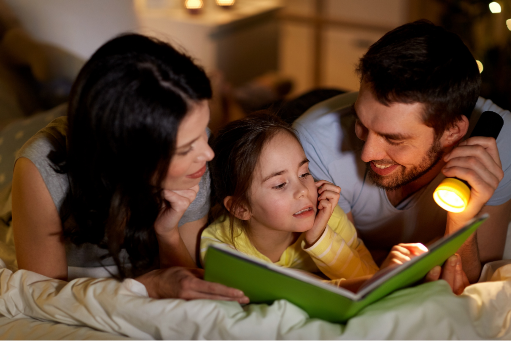 Mom and Dad reading with child at bedtime